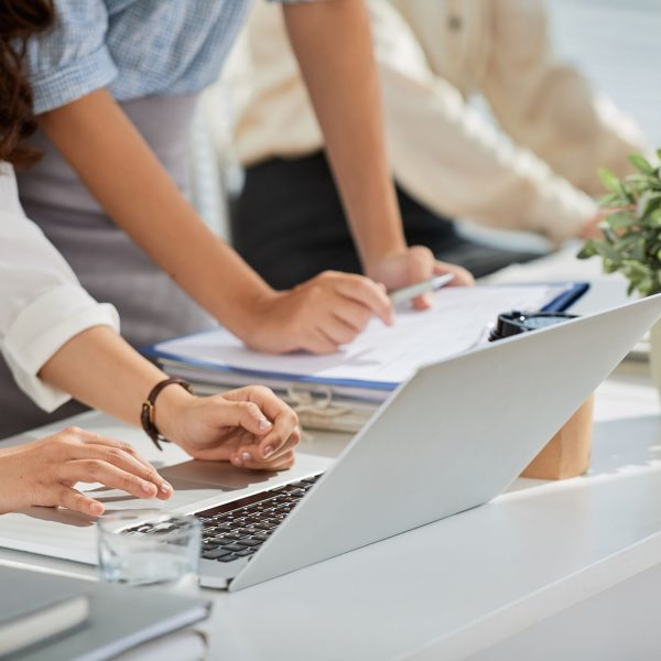 Cropped image of business ladies reading e-mails on laptop screen